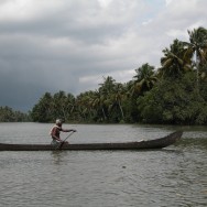 a man on a canoe trying to get home before the storm in Kerala's backwaters, in south India