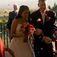 Subadra and Karl fleeing under a rain of flower petals during their wedding at Auberge du Soleil in Napa Valley, California, USA