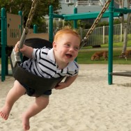 Devon happily flying around on a swingset at the playground in Encinitas, California, USA