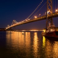 reflections of the lights on the Oakland Bay Bridge on the water in San Francisco, California, USA