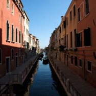 a canal surrounded by red buildings in the Dorsoduro neighbourhood of Venice, Italy