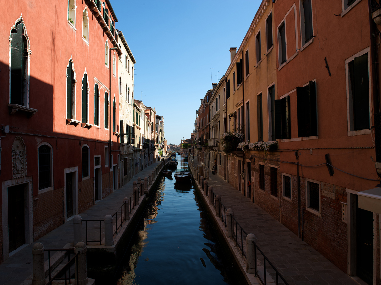 a canal surrounded by red buildings in the Dorsoduro neighbourhood of Venice, Italy