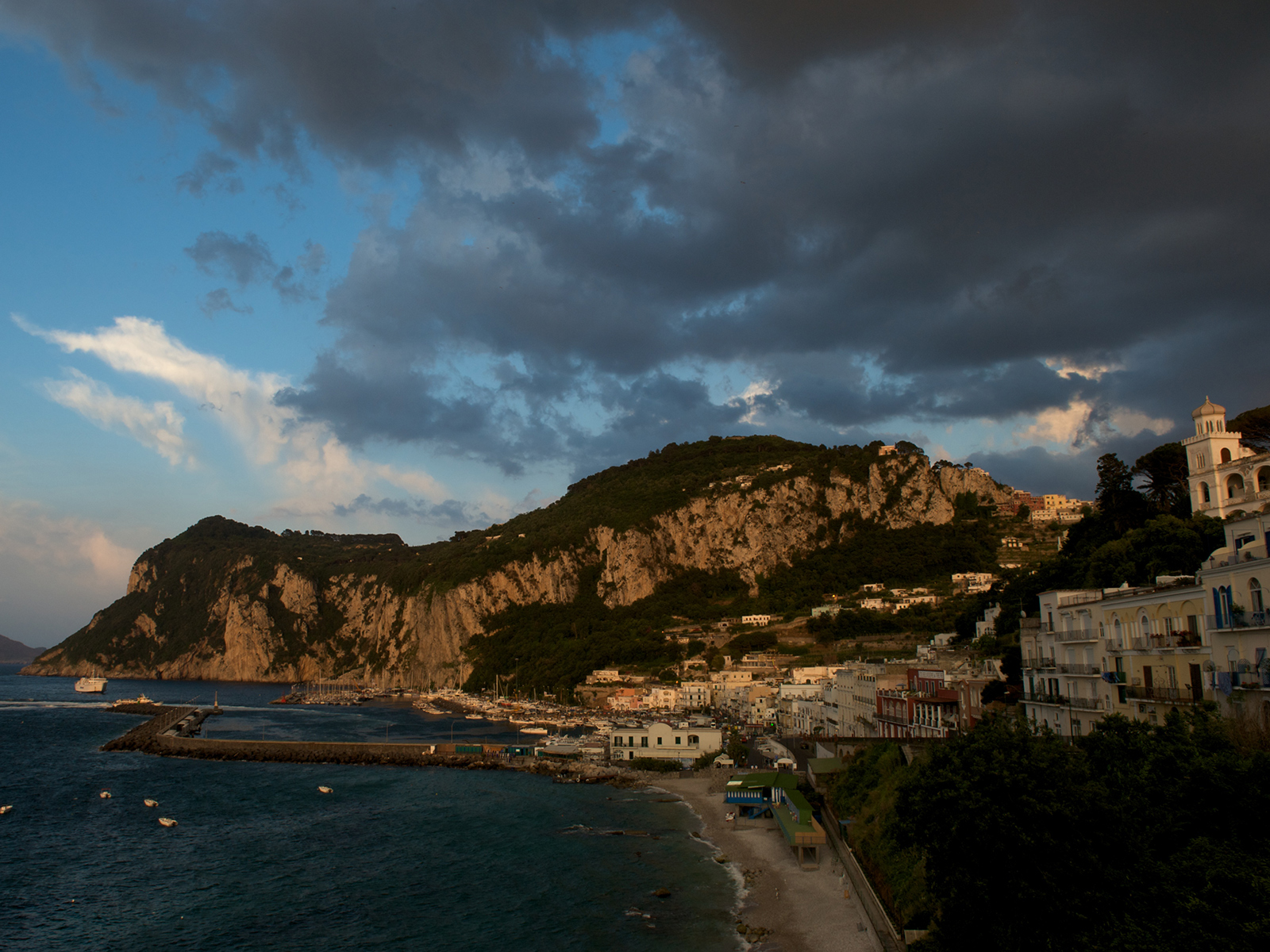 dark clouds gather above the harbour in the town of Capri, Italy